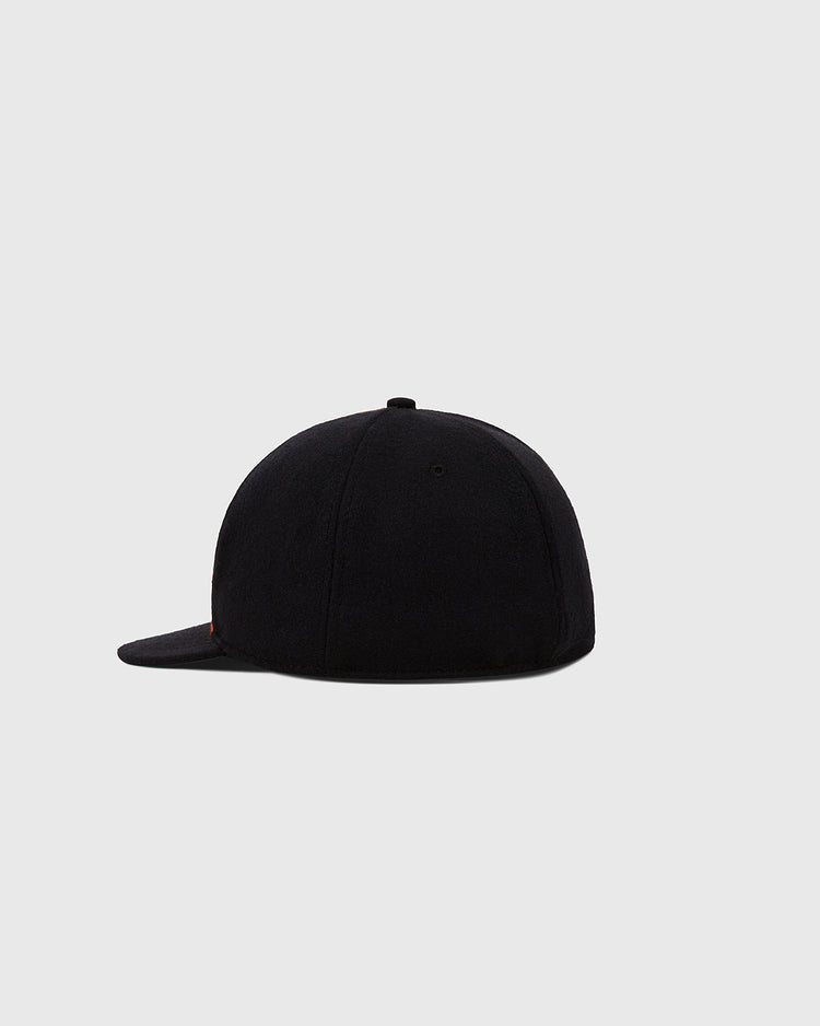 The EFF Sioux City Ghosts 1935 Authentic Wool Softbrim Ballcap, shown in plain black from the back and slightly to the side, is inspired by a vintage baseball hat and set against a light gray background.