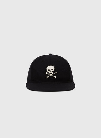 The Ebbets Field Sioux City Ghosts Vintage Inspired Wool Ballcap is a black cap with a white skull and crossbones on the front, shown against a plain light gray background.