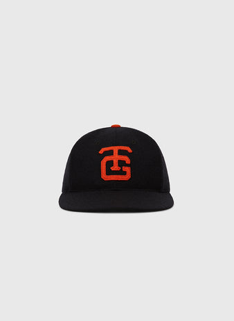 The Ebbets Field Tokyo Giants 1952 Authentic Wool Ballcap is a black cap with a flat brim and bold red TC logo, inspired by the classic 1952 style, shown against a plain light gray background.