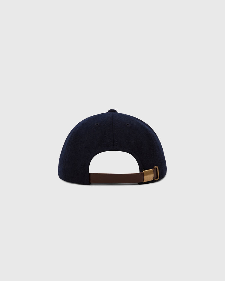 The Ebbets Field Hiroshima Carp 1959 Authentic 8-Panel Wool Ballcap in navy, shown from the back with a brown adjustable strap and gold buckle, is set against a plain light gray background.