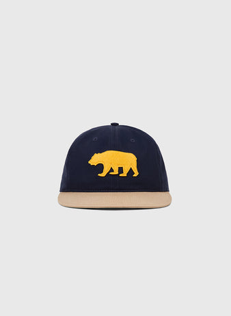 The Ebbets Field Mission Bears Cotton Twill Ballcap, in navy with a beige brim and yellow bear emblem inspired by the 1926 team, is displayed on a plain light gray background.