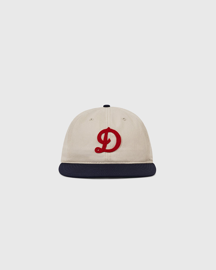 The Ebbets Field Detroit Stars Cotton Twill Ballcap is a beige cap with a navy blue brim and red D, inspired by the 1920 team, shown on a plain light gray background.