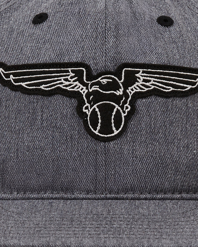 A close-up of the Ebbets Field Newark Eagles Cotton Twill Ballcap shows an embroidered 1938 team logo: a bird clutching a baseball in its talons, wings outstretched, outlined in black and white.