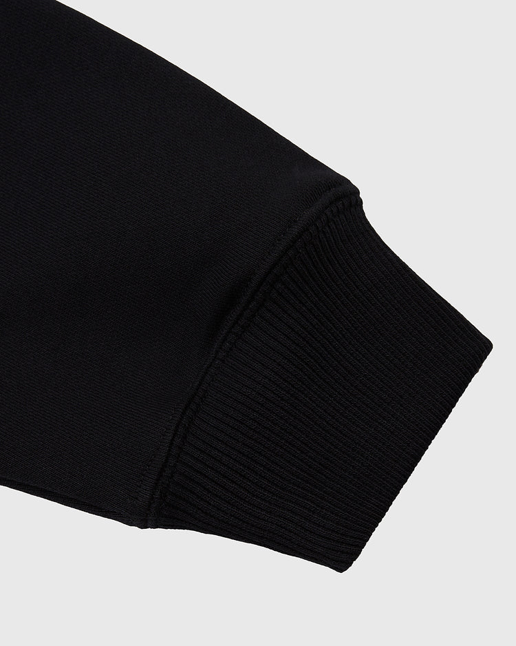 Close-up of the cuff on the Ebbets Field Tokyo Giants Heavyweight Cotton Terry Full-Zip Hoodie, featuring ribbed, elastic material at the wrist against a plain light gray background.