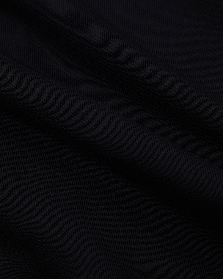 Close-up of black ribbed fabric with visible texture and gentle folds, showcasing the softness and flexibility of the Ebbets Field Tokyo Giants Heavyweight Cotton Terry Full-Zip Hoodie.