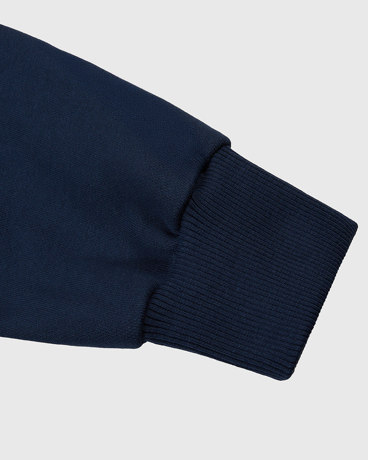 Close-up of the Babe Ruth Heavyweight Cotton Terry Full-Zip Hoodie by Ebbets Field, showing its navy ribbed cuff against a light gray background—a classic hoodie inspired by legendary baseball comfort.