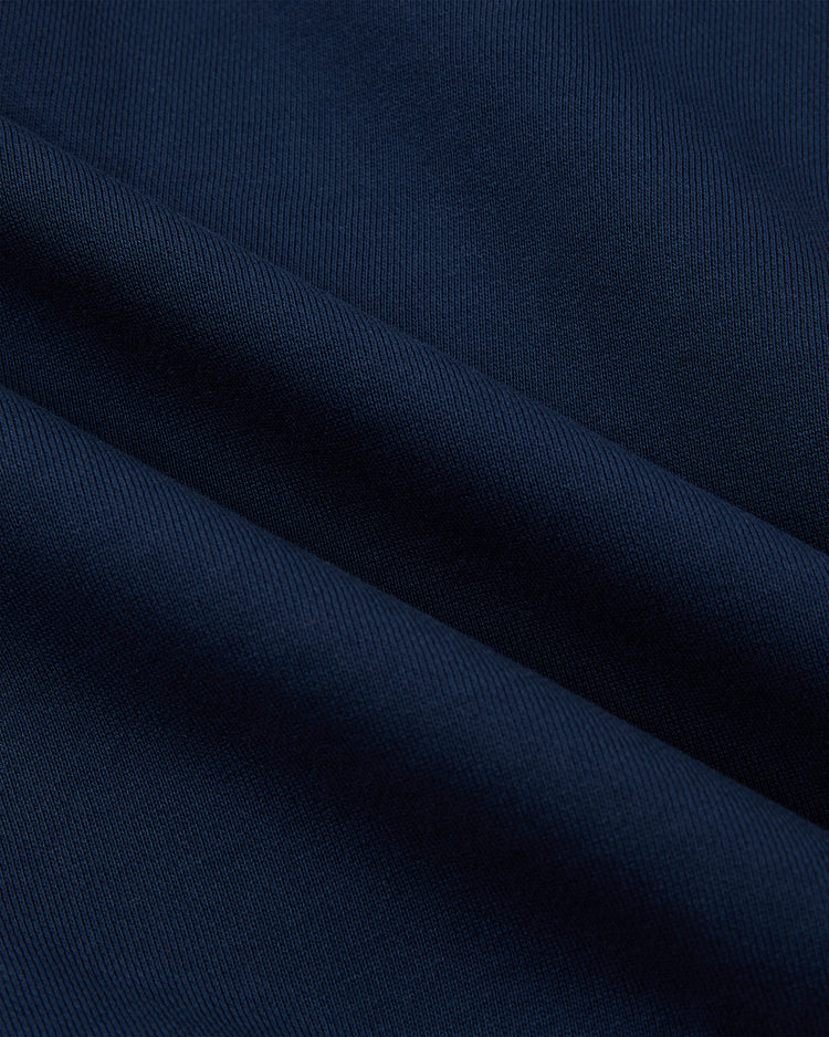 Close-up of dark navy blue heavyweight cotton terry, featuring a smooth texture and subtle diagonal folds—ideal for the Ebbets Field Babe Ruth Full-Zip Hoodie. The fine weave and rich color give it a timeless, sporty look.