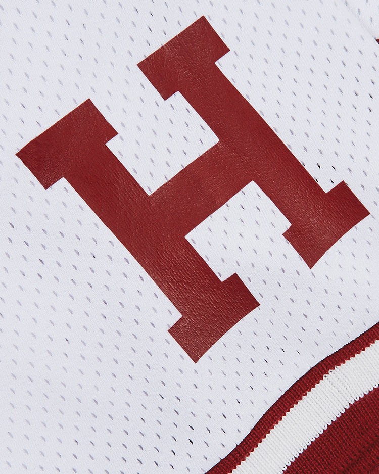 The Harvard Vintage Mesh Football Jersey by Ebbets Field features a bold red “H” on white athletic mesh, finished with red and white striped trim for a classic throwback look.