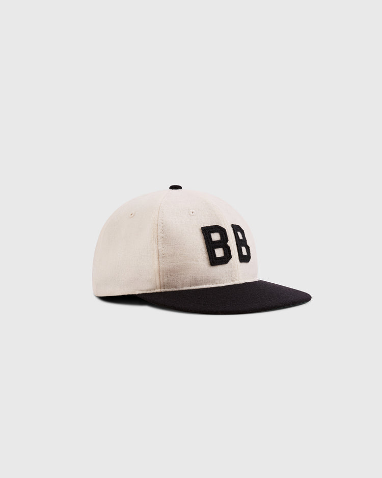 The Ebbets Field Babe Ruth Bustin' Babes Authentic Wool Ballcap is beige with a black brim and bold black BB embroidery, inspired by Babe Ruth’s barnstorming tours, displayed on a plain white background.