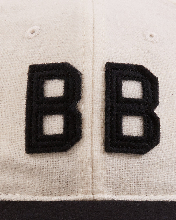 Close-up of the Ebbets Field Babe Ruth Bustin' Babes Authentic Wool Ballcap shows beige fabric with two large black embroidered 