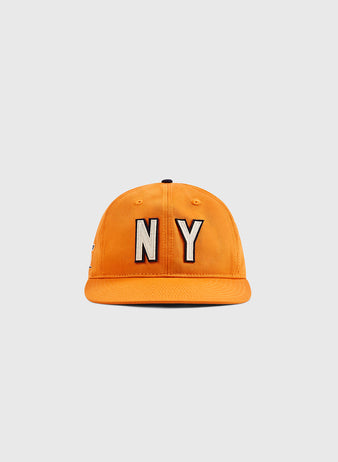 An orange Ebbets Field New York 1939 World's Fair cotton twill ballcap with bold black and white NY embroidery displayed on a plain, light gray background.
