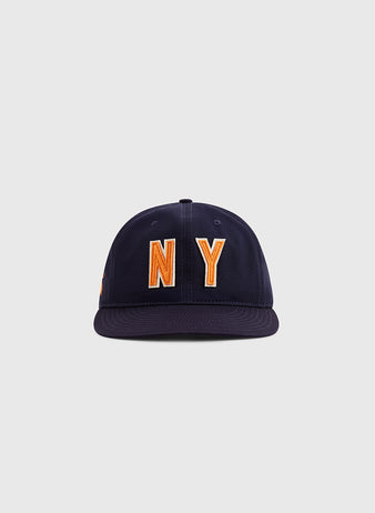 The Ebbets Field New York 1939 World's Fair Cotton Twill Ballcap features large orange and white “NY” embroidery on navy blue, inspired by Babe Ruth’s era, shown against a plain light gray background.