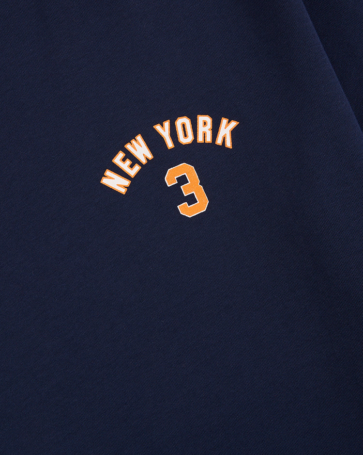 Close-up of navy blue fabric with NEW YORK in orange, curved above a bold orange 3—a simple, centered Ebbets Field New York 1939 World's Fair Short Sleeve Graphic Tee inspired by classic Yankees style.