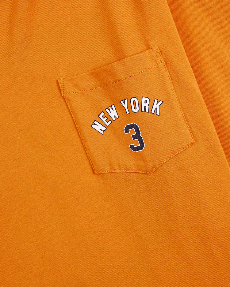 The Ebbets Field New York 1939 World's Fair Long Sleeve Graphic Tee is an orange shirt with a chest pocket, displaying 