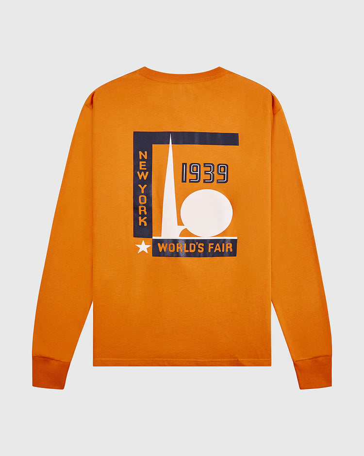 The Ebbets Field New York 1939 World's Fair Long Sleeve Graphic Tee is an orange Yankees shirt with navy and white geometric back graphics, including a triangle, circle, and 