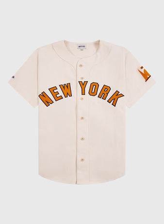 The Ebbets Field New York 1939 World's Fair Cotton Baseball Jersey is a white jersey with orange lettering inspired by classic Babe Ruth-era style.
