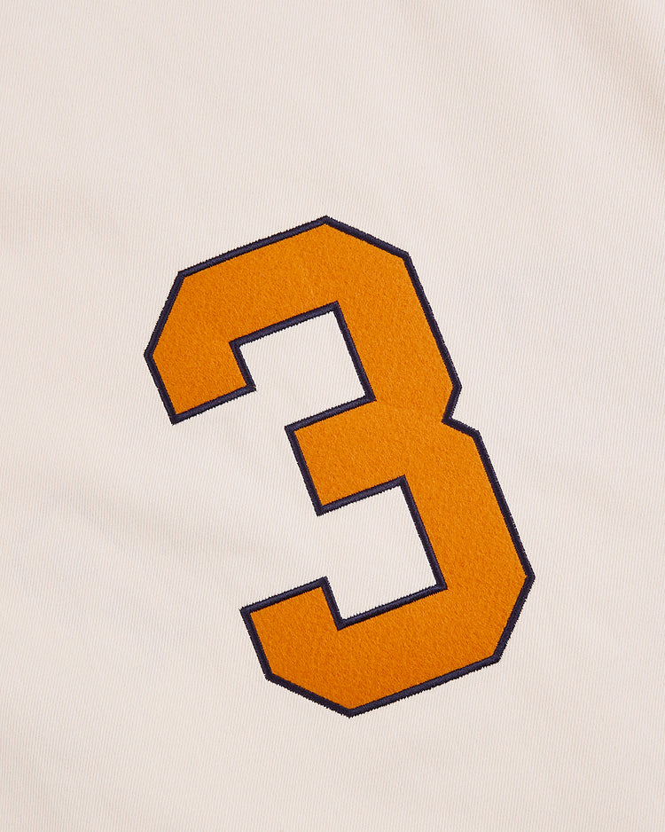 A large, orange number 3 outlined in black stands out on the white, textured cotton of the Ebbets Field New York 1939 World's Fair Baseball Jersey.