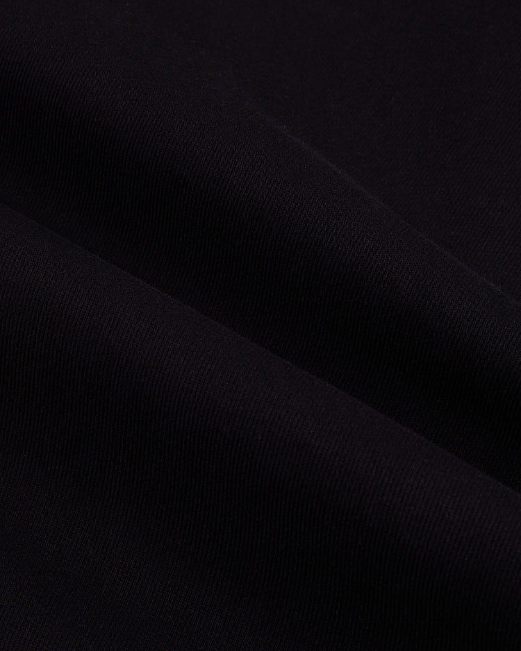 Close-up of black fabric with subtle texture, echoing the soft folds of an Ebbets Field Babe Ruth Bustin' Babes Cotton Twill Baseball Jersey, inspired by the 1927 barnstorming tour.