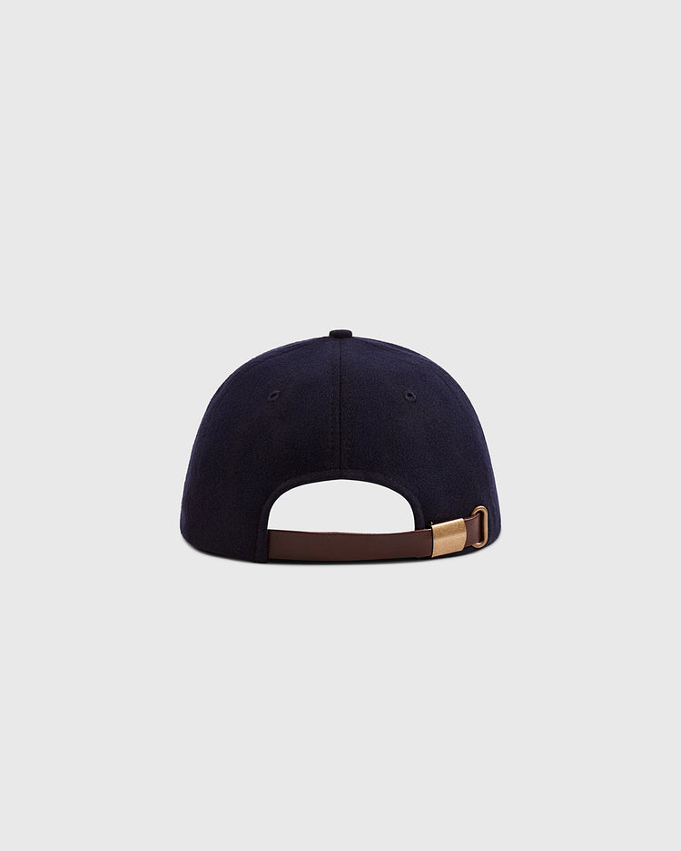 The Ebbets Field Grateful Dead Double Bolt Wool Ballcap is shown from the back, in navy blue wool broadcloth, with a brown adjustable strap and gold buckle—an homage to the 60th anniversary style—against a light gray background.