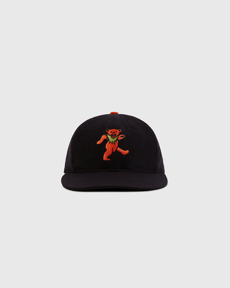 The Ebbets Field Grateful Dead Dancing Bear Wool Ballcap in black features an orange embroidered dancing bear on the front, shown against a light gray background.