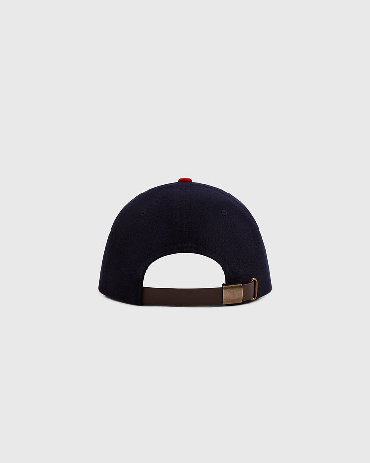 A navy blue Ebbets Field Mystery Caps of Mexico – Carta Blanca 1939 Authentic Wool Ballcap shown from the back, featuring a brown adjustable strap with metal buckle against a light gray background—an homage to Mexican baseball history.