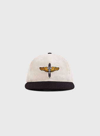 The Ebbets Field Mystery Caps of Mexico – Aviacion 1917 Authentic Wool Ballcap features a cream crown, black brim, and an embroidered gold and black winged emblem, celebrating Mexican baseball history against a white backdrop.