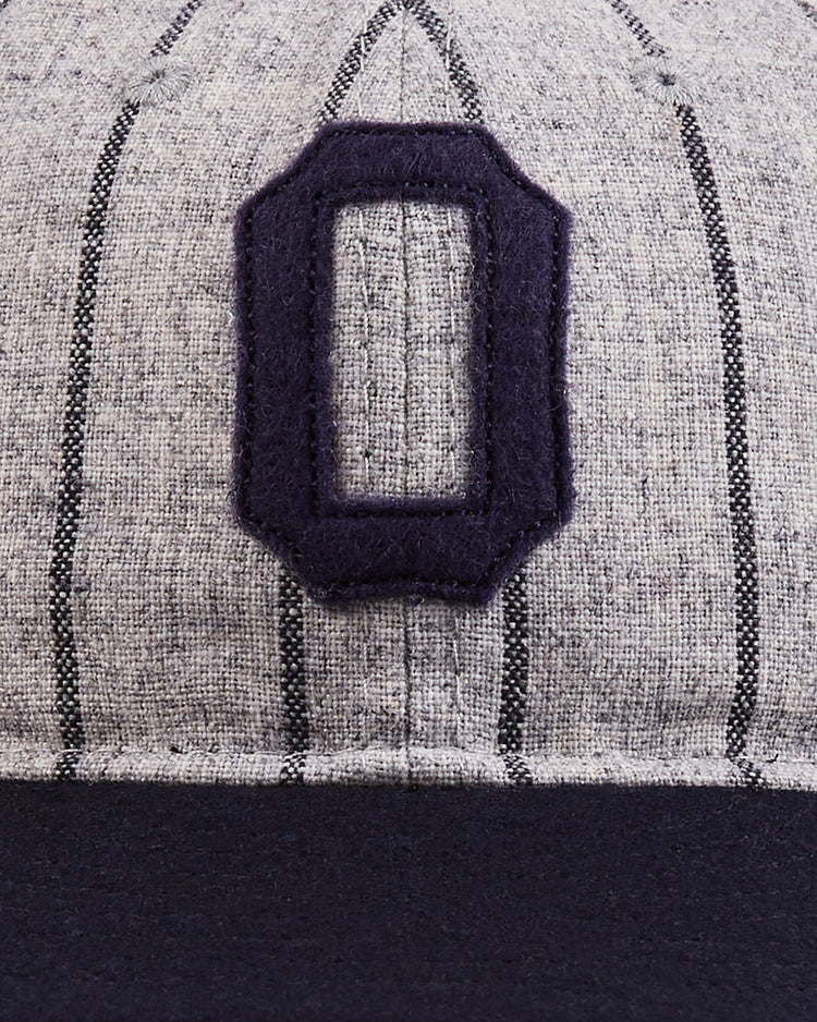 Close-up of the Osaka Tigers 1945 Authentic Wool Ballcap by Ebbets Field, featuring gray wool with black pinstripes, a bold black 