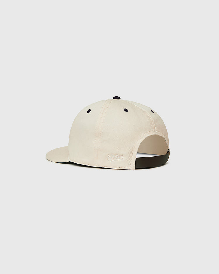 The Ebbets Field New York 1939 World's Fair Cotton Twill Ballcap features a beige design with a curved brim, black ventilation eyelets, and an adjustable black strap, displayed on a plain white background.