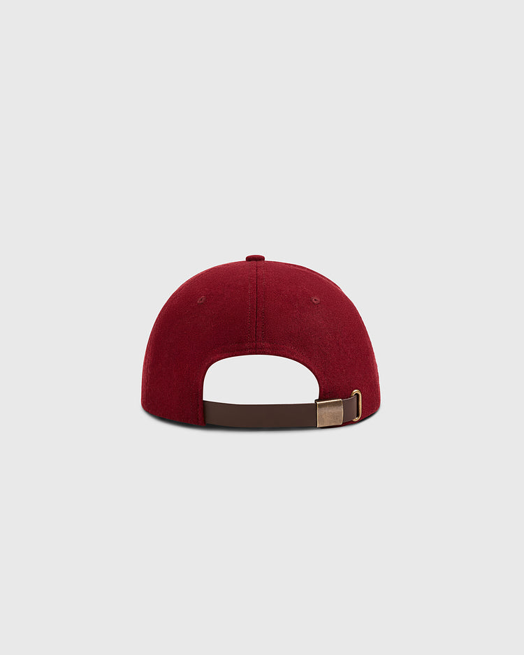 A burgundy Mystery Caps of Mexico – Delta Authentic Wool Ballcap by Ebbets Field, shown from the back with a brown adjustable strap and metal clasp, stands out against a light gray background—ideal for fans of Mexican baseball history.