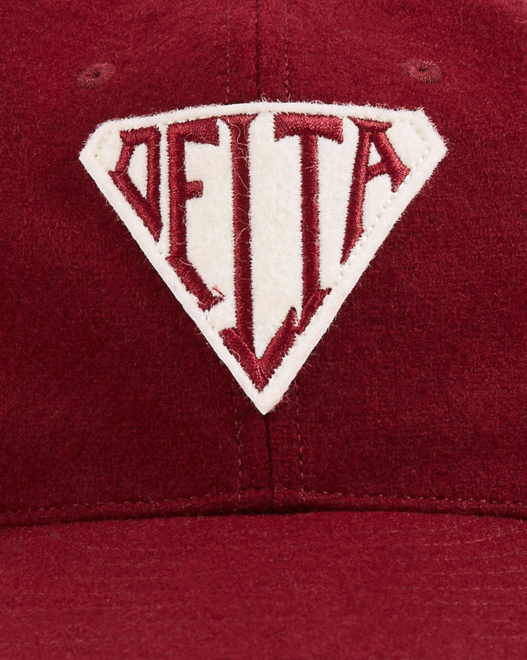 A close-up of the Ebbets Field Mystery Caps of Mexico – Delta Authentic Wool Ballcap, a vintage-style maroon cap with a white diamond patch and 