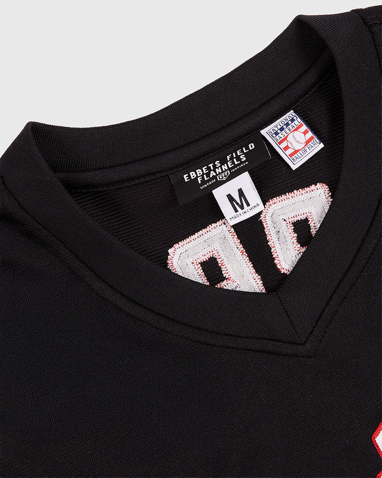 Close-up of the collar and tags on an EFF Harrisburg Senators MiLB Vintage V-Neck Baseball Jersey in black (size M), showing part of a white and red stitched number 90 on the front.