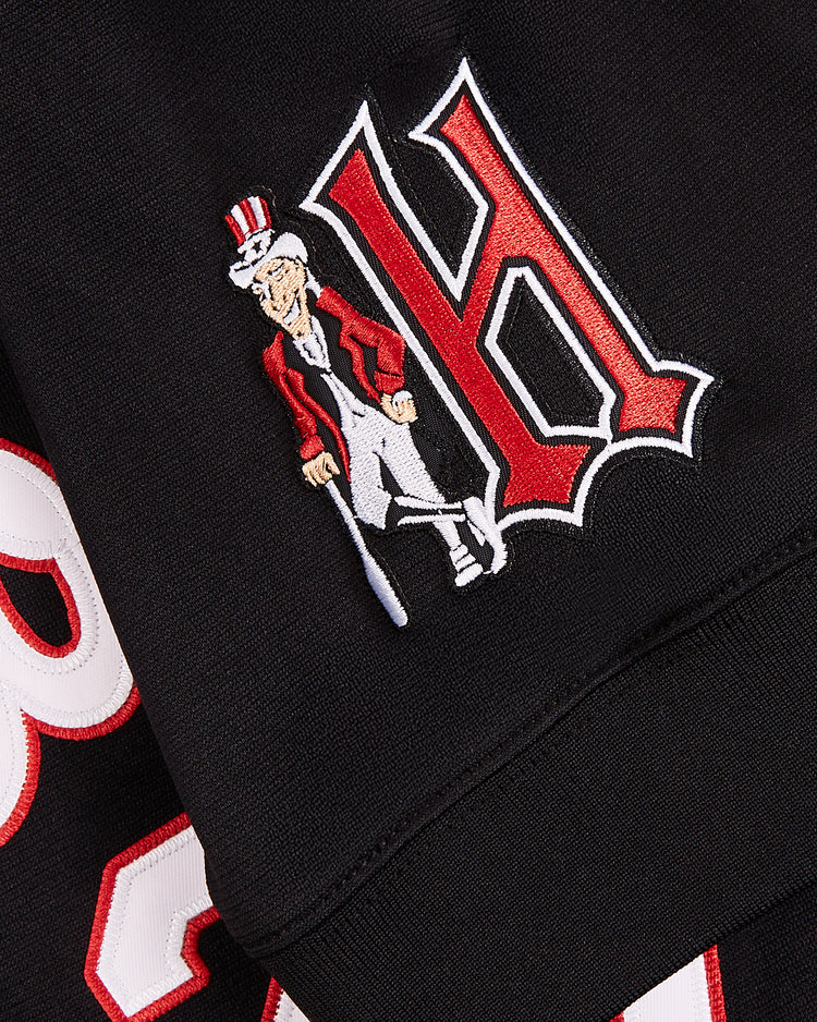 A close-up of the Harrisburg Senators EFF MiLB Vintage V-Neck Baseball Jersey by EFF, showing black fabric with a large red and white embroidered 