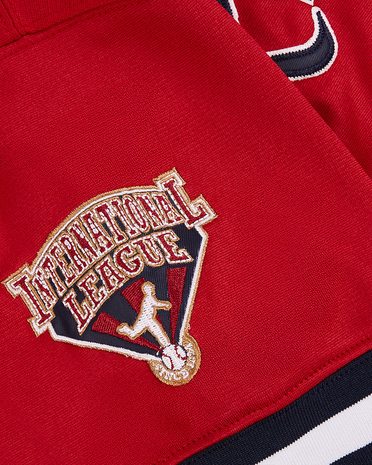 A close-up of a red fabric patch reading “International League” above a silhouette on the John Smoltz Richmond Braves V-Neck Jersey by Ebbets Field, with black and white trim visible.