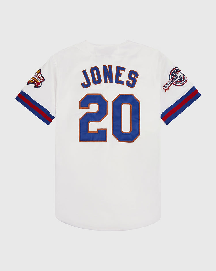 The Ebbets Field Chipper Jones Durham Bulls Button Up Jersey is white, with JONES and number 20 in blue and gold on the back, colorful sleeve patches, and blue/red cuff stripes—a classic tribute to the legend.