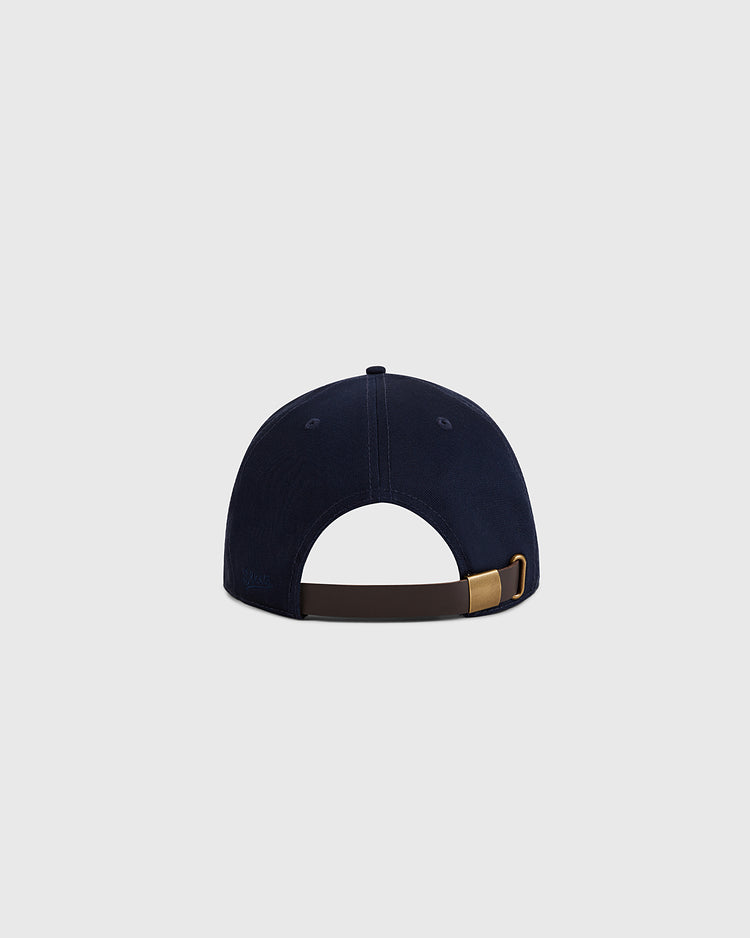 The Navy Cotton Twill Ballcap by Ebbets Field is shown from the back with a brown adjustable strap and gold buckle, crafted from cotton twill, set against a plain light gray background.