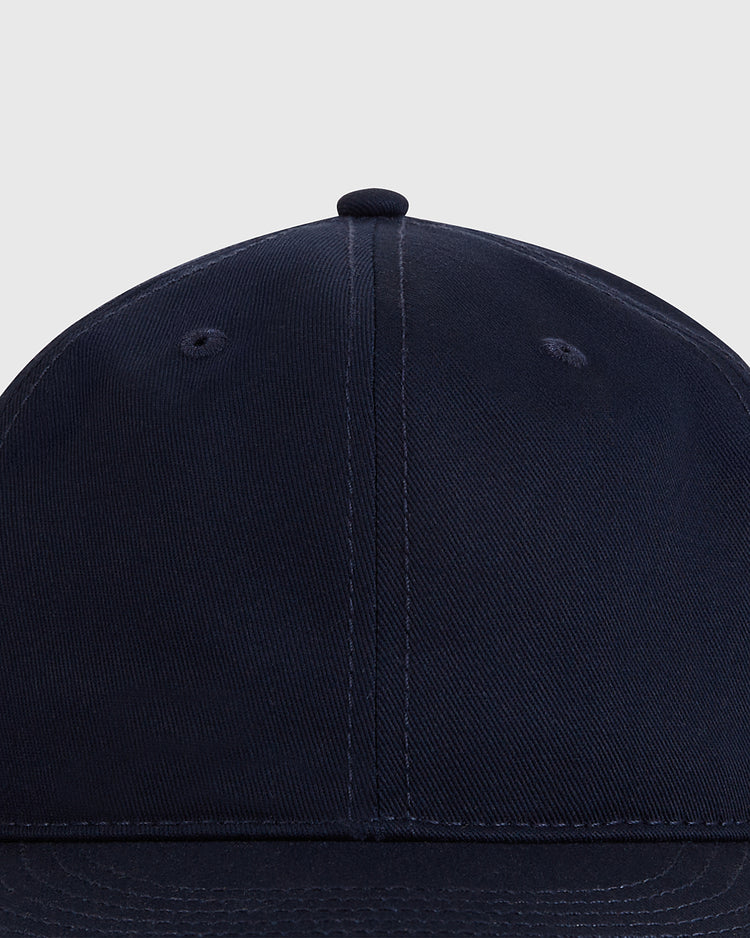 Close-up of the front and top of the Ebbets Field Navy Cotton Twill Ballcap, a vintage-style baseball cap crafted from cotton twill, shown against a light grey background.
