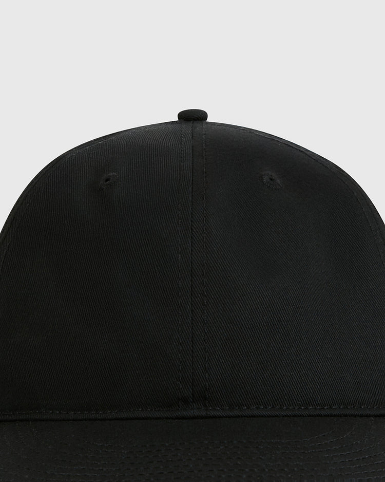 A close-up view of the front panel and curved brim of the Ebbets Field Black Cotton Twill Ballcap, shown against a light gray background.