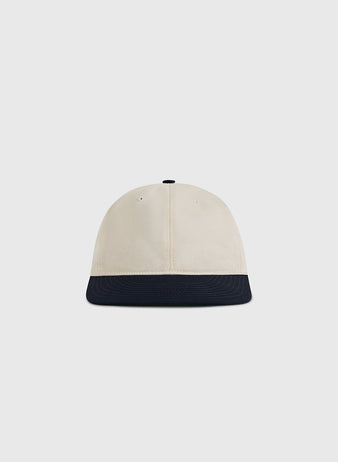 The Ebbets Field Natural and Navy Cotton Twill Ballcap is shown from the front, featuring a cream-colored crown and a navy brim against a plain light background.
