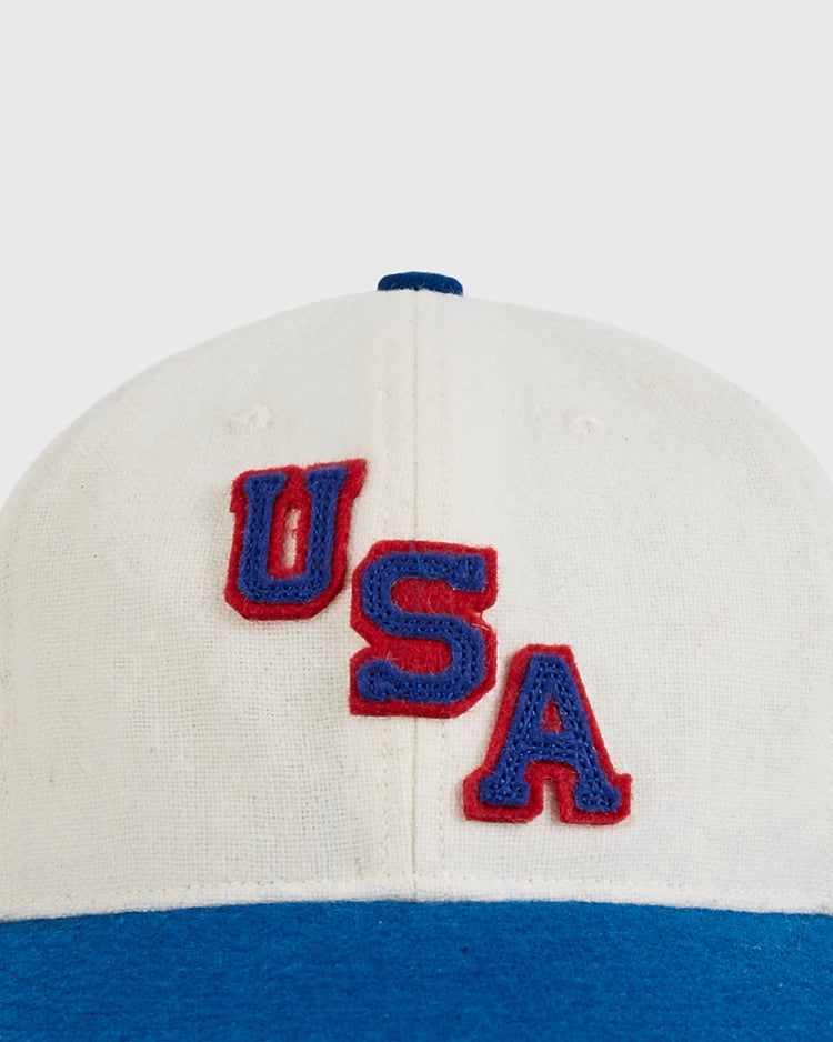 A close-up of the Ebbets Field USA Miracle On Ice 1960 Wool Ballcap, a white and blue vintage-style hat featuring 