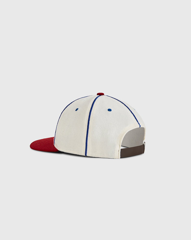 The Ebbets Field Oakland Oaks 1942 Authentic Wool Ballcap features a white crown, blue stitching, red brim, brown adjustable strap, and the classic acorn logo—shown on a plain light gray background.