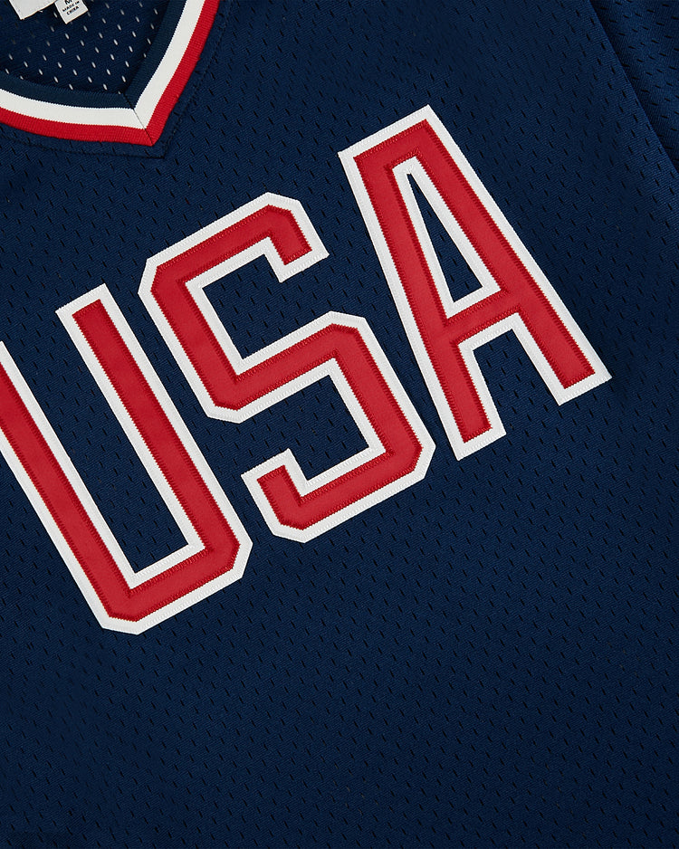 A close-up of the Ebbets Field USA National Team Mesh V-Neck Jersey in navy blue mesh, featuring bold white and red 