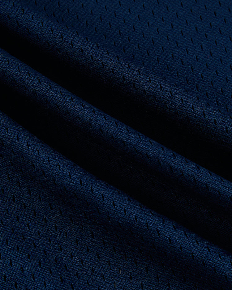 Close-up of Ebbets Field's USA National Team Mesh V-Neck Jersey shows dark blue mesh fabric with small, evenly spaced perforations and soft folds, recalling the look and texture of a vintage baseball jersey.