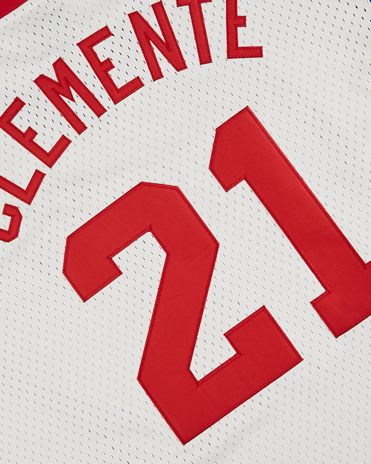 A close-up of the Ebbets Field Puerto Rico 1976 National Team Mesh V-Neck Jersey: a white top with red letters and number 21, part of the name Clemente visible, echoing Roberto Clemente’s iconic look.