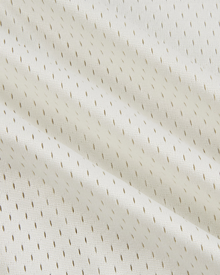 A close-up of the Ebbets Field Puerto Rico 1976 National Team Mesh V-Neck Jersey, featuring light beige fabric with a subtle diagonal wave pattern and small, evenly spaced perforations for a vintage look.