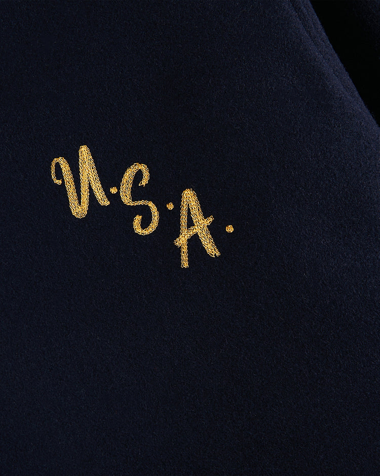 The Ebbets Field USA 1960 Miracle On Ice All-Wool Varsity Jacket features navy blue fabric and yellow “U.S.A.” embroidery, inspired by the vintage Olympic hockey gold moment.