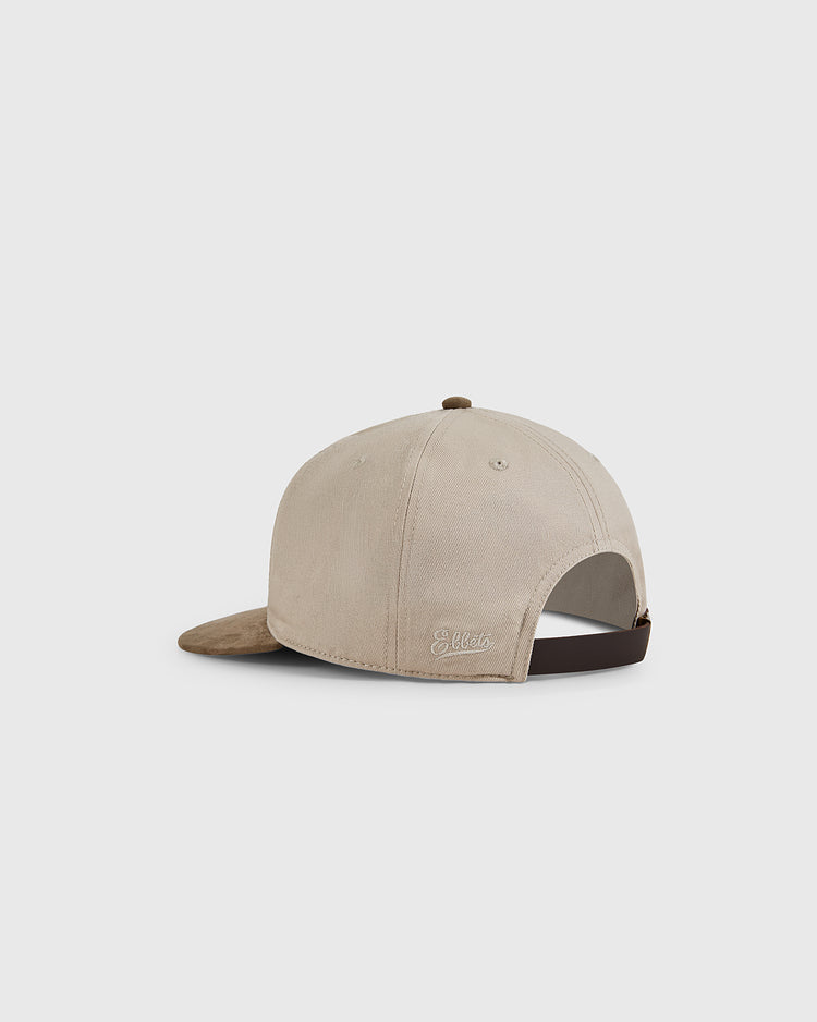 The Ebbets Field New York Cubans 1948 Cotton Twill Suede Ballcap is beige with a brown suede bill, adjustable dark strap, and small embroidered logo—paying tribute to Negro League teams. Shown from the back against a white background.