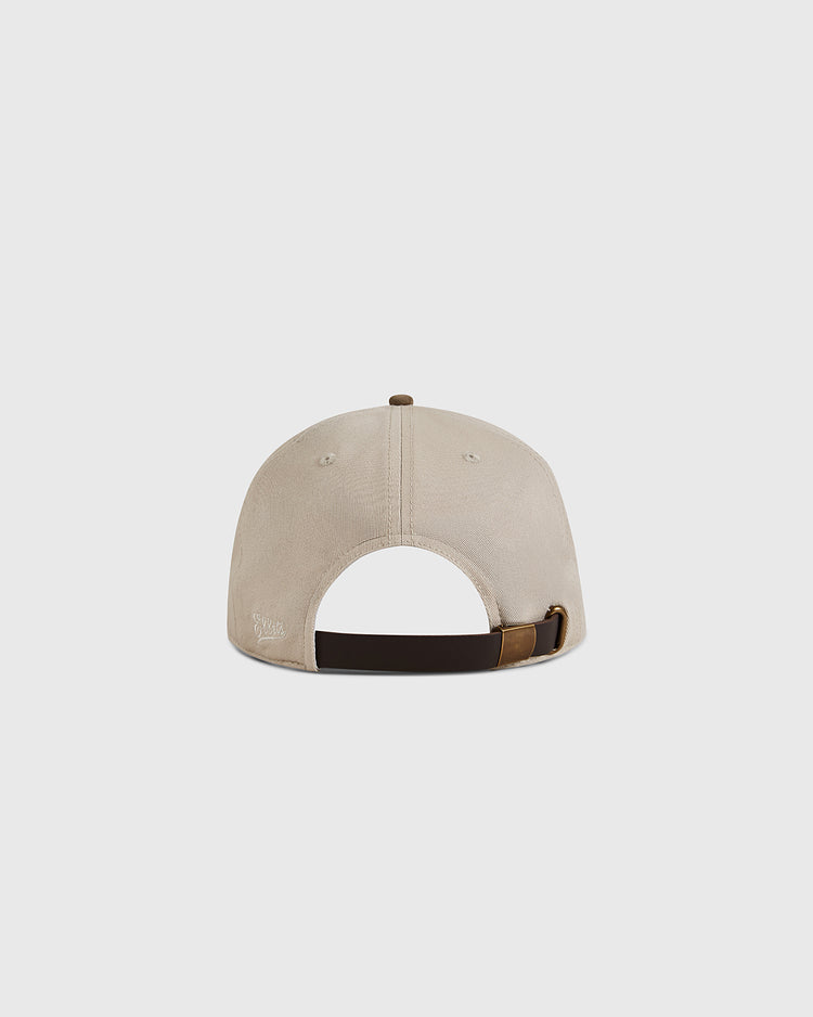 The Ebbets Field New York Cubans 1948 Cotton Twill Suede Ballcap in beige features an adjustable dark brown strap and a small Negro League–inspired stitched logo on the lower left, shown from the back against a light gray background.