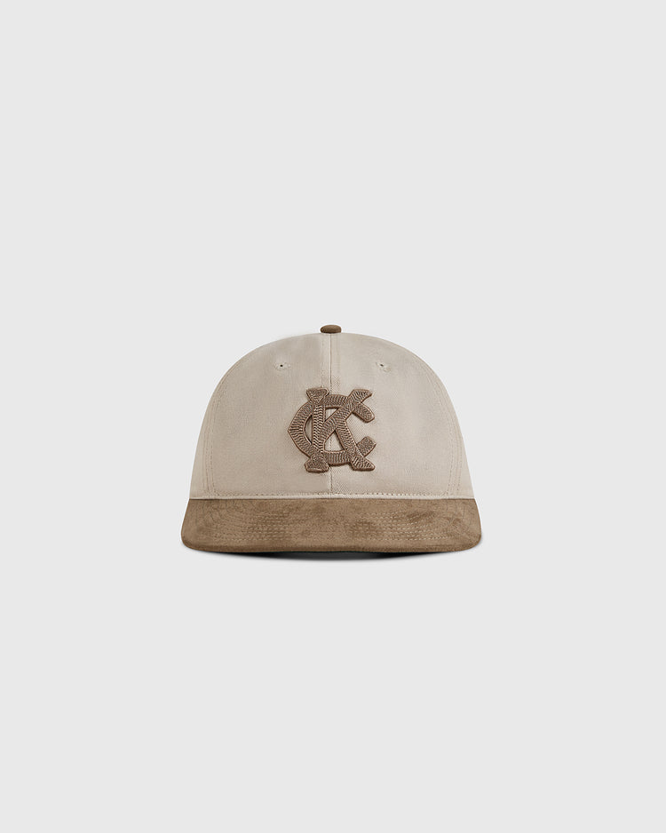 The Ebbets Field Kansas City Monarchs 1945 Cotton Twill Suede Ballcap features a beige crown, brown suede brim, and embroidered overlapping KC logo, shown against a plain white background.