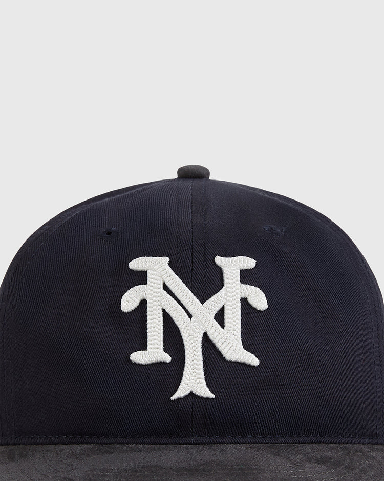 The Ebbets Field New York Cubans 1948 Cotton Twill Suede Ballcap features a navy blue design with a white interlocking NY logo, inspired by Negro League baseball, shown against a light gray background.