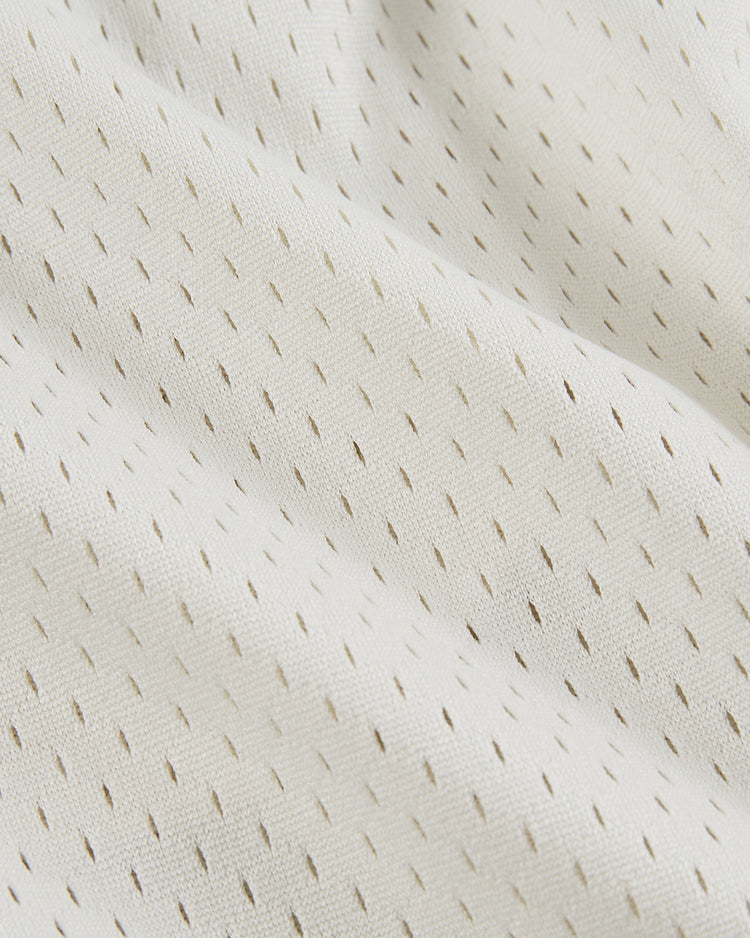 Close-up of Ebbets Field's USA National Team Mesh Shorts, featuring soft white textured fabric with small, evenly spaced perforations for breathability and comfort, reminiscent of classic baseball mesh shorts.